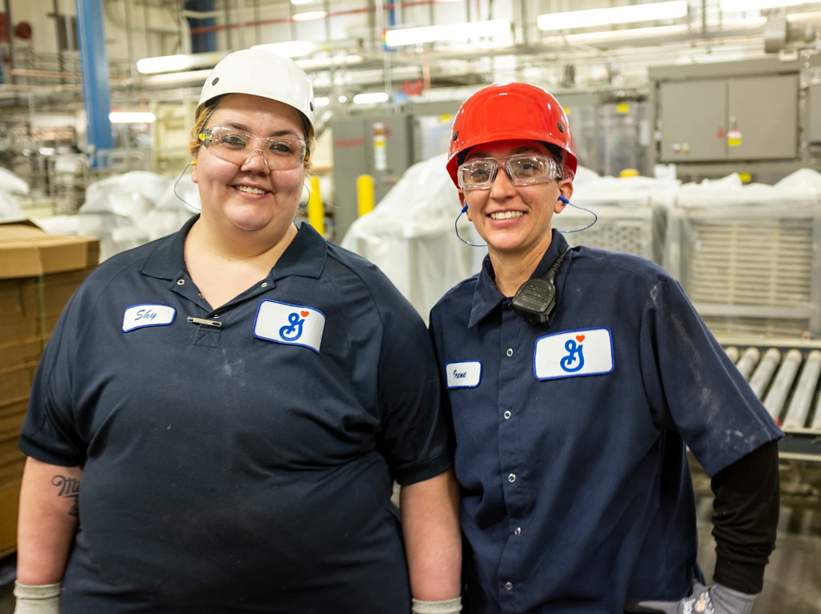 Two female manufacturing employees smiling at the camera